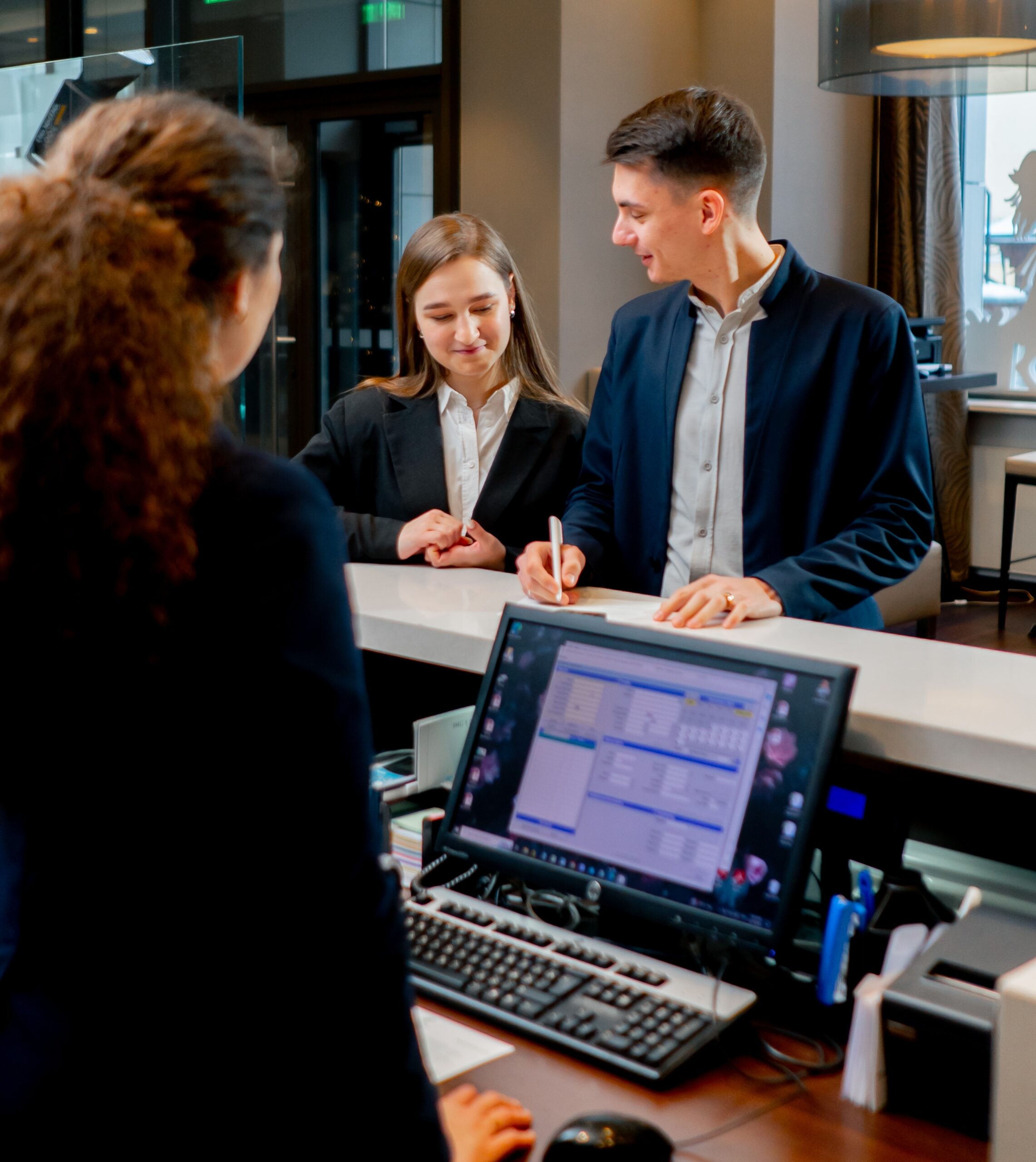 The,Receptionist,At,The,Counter,Meets,Guests,With,Luggage,In